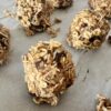 A baking sheet filled with freshly made homemade granola balls, showcasing their round shape and golden-brown color.