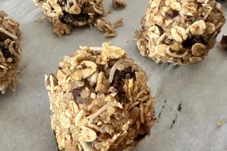 A baking sheet filled with freshly made homemade granola balls, showcasing their round shape and golden-brown color.