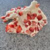 A piece of white chocolate bark adorned with fresh strawberries, showcasing a delightful combination of flavors and textures.