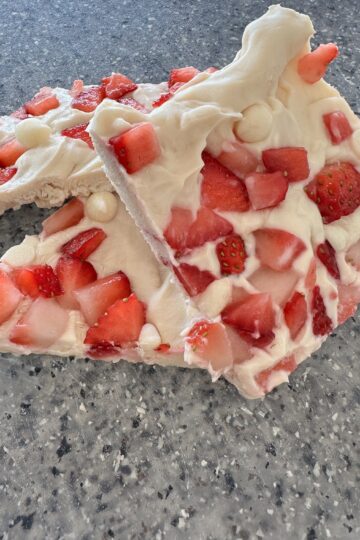 A piece of white chocolate bark adorned with fresh strawberries, showcasing a delightful combination of flavors and textures.