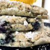 A stack of blueberry oatmeal pancakes topped with a lemon wedge, showcasing a delicious vegan breakfast option.